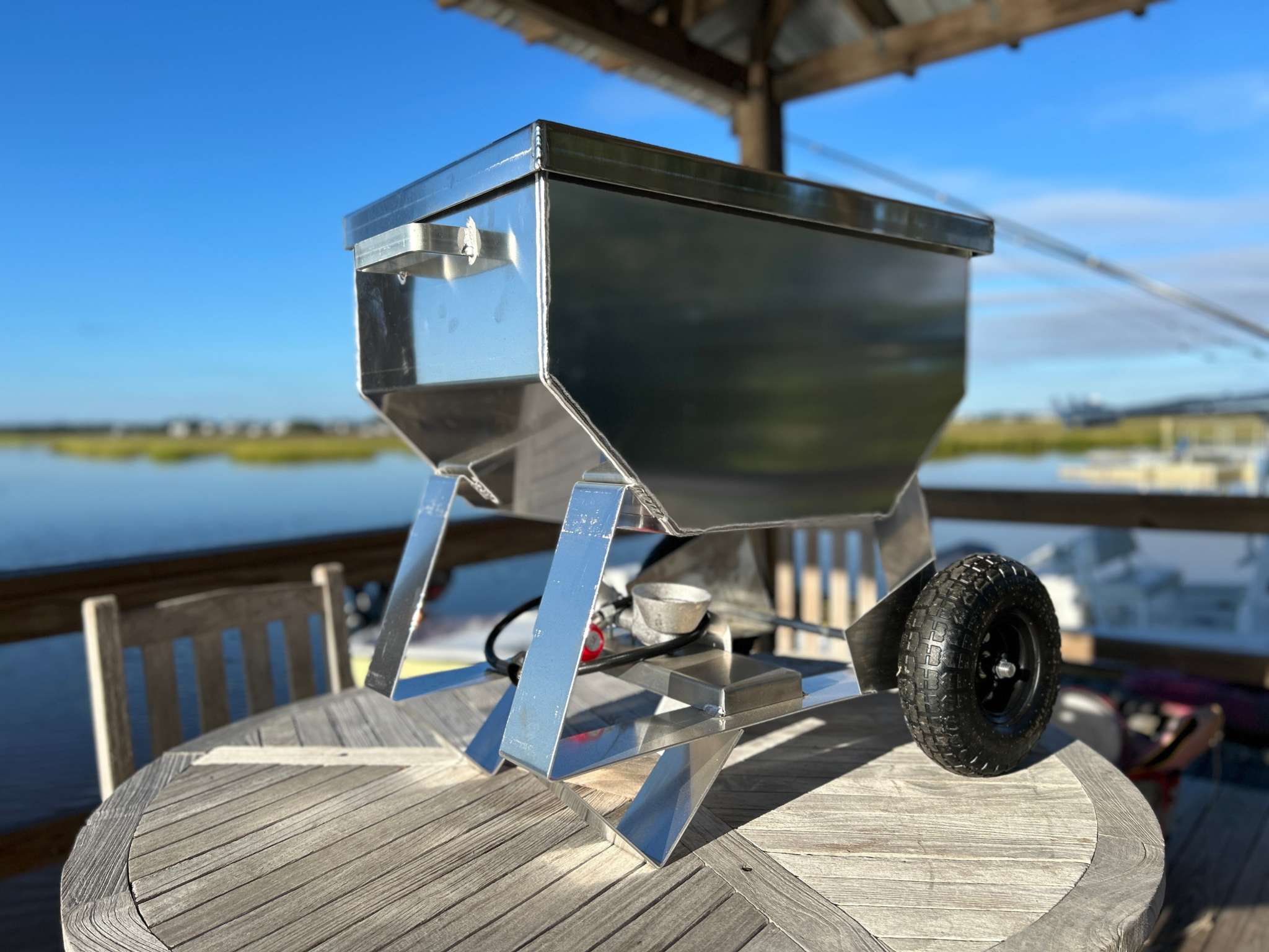 Wheeled Classic Cooker with pneumatic tires on outdoor deck by water.