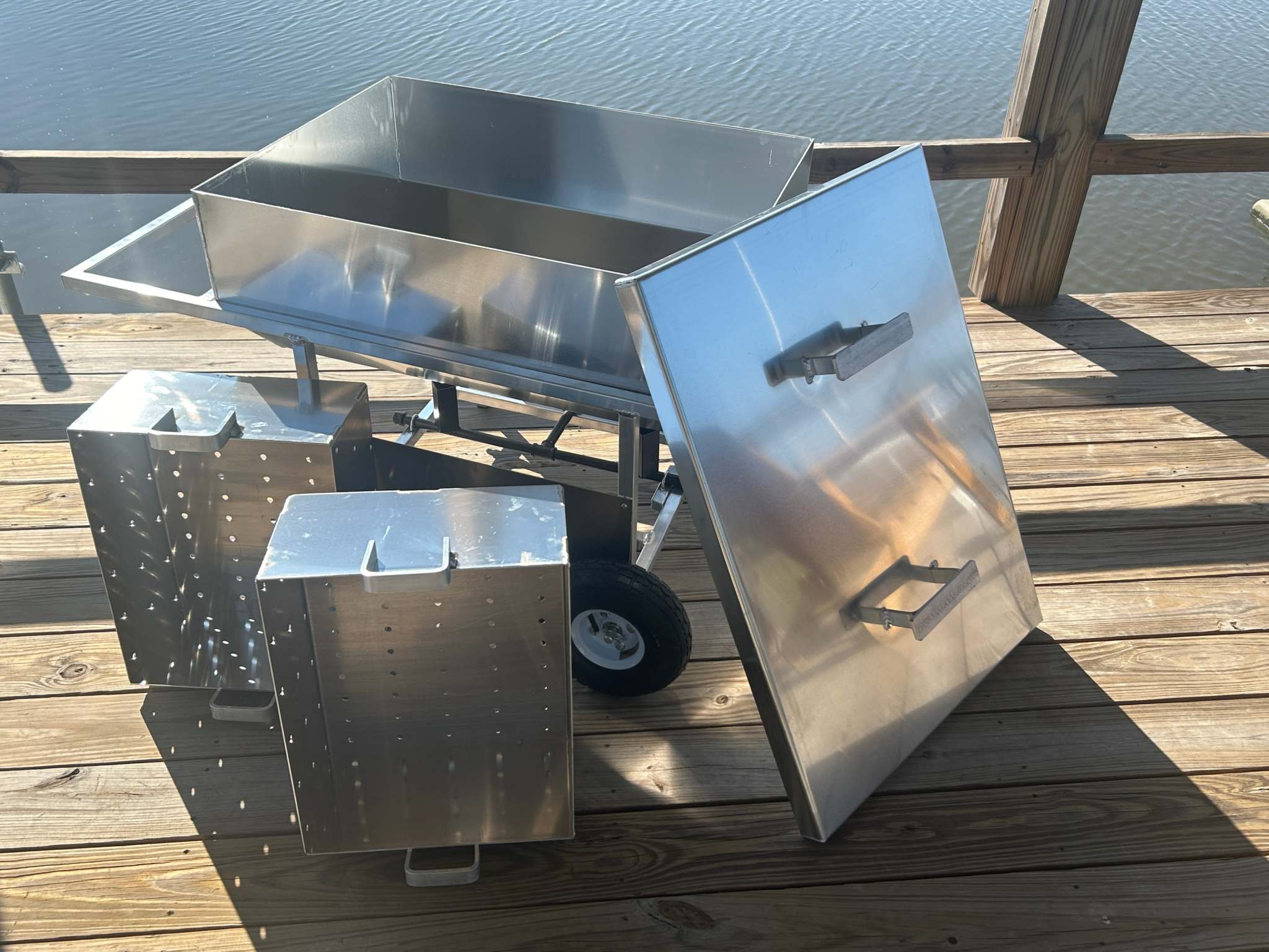Double Basket Classic wheeled cooker, premium aluminum, ideal for shellfish steaming, on wooden deck by water.