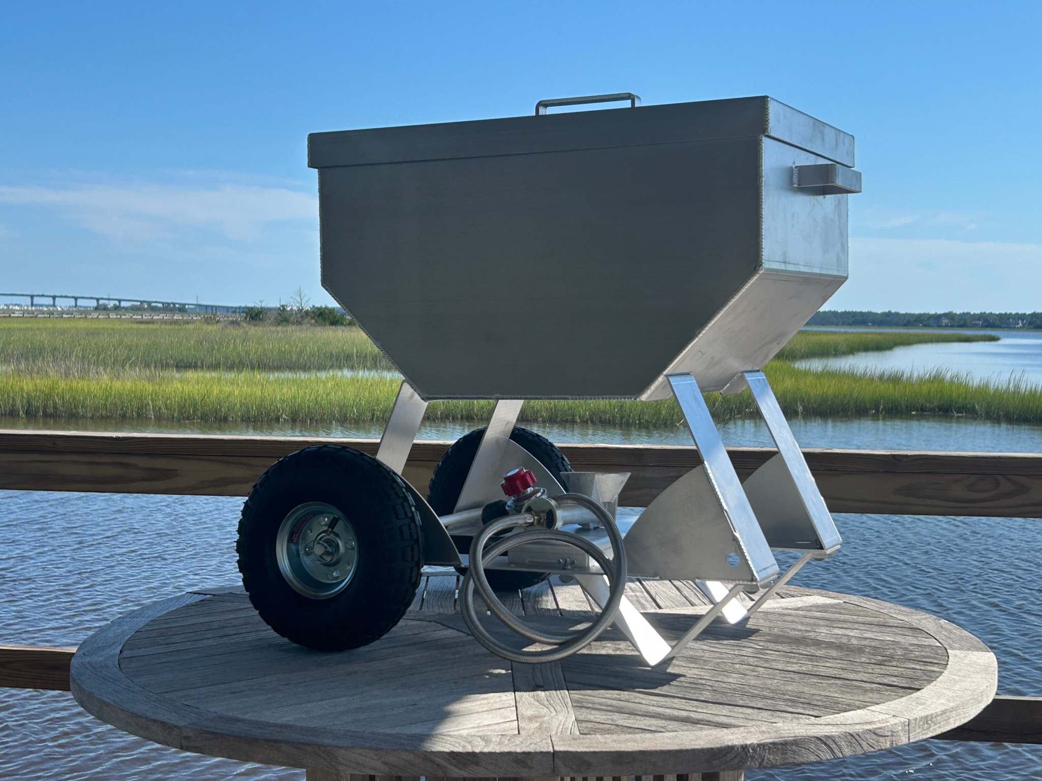 Wheeled Classic marine-grade aluminum seafood cooker with pneumatic tires by waterfront