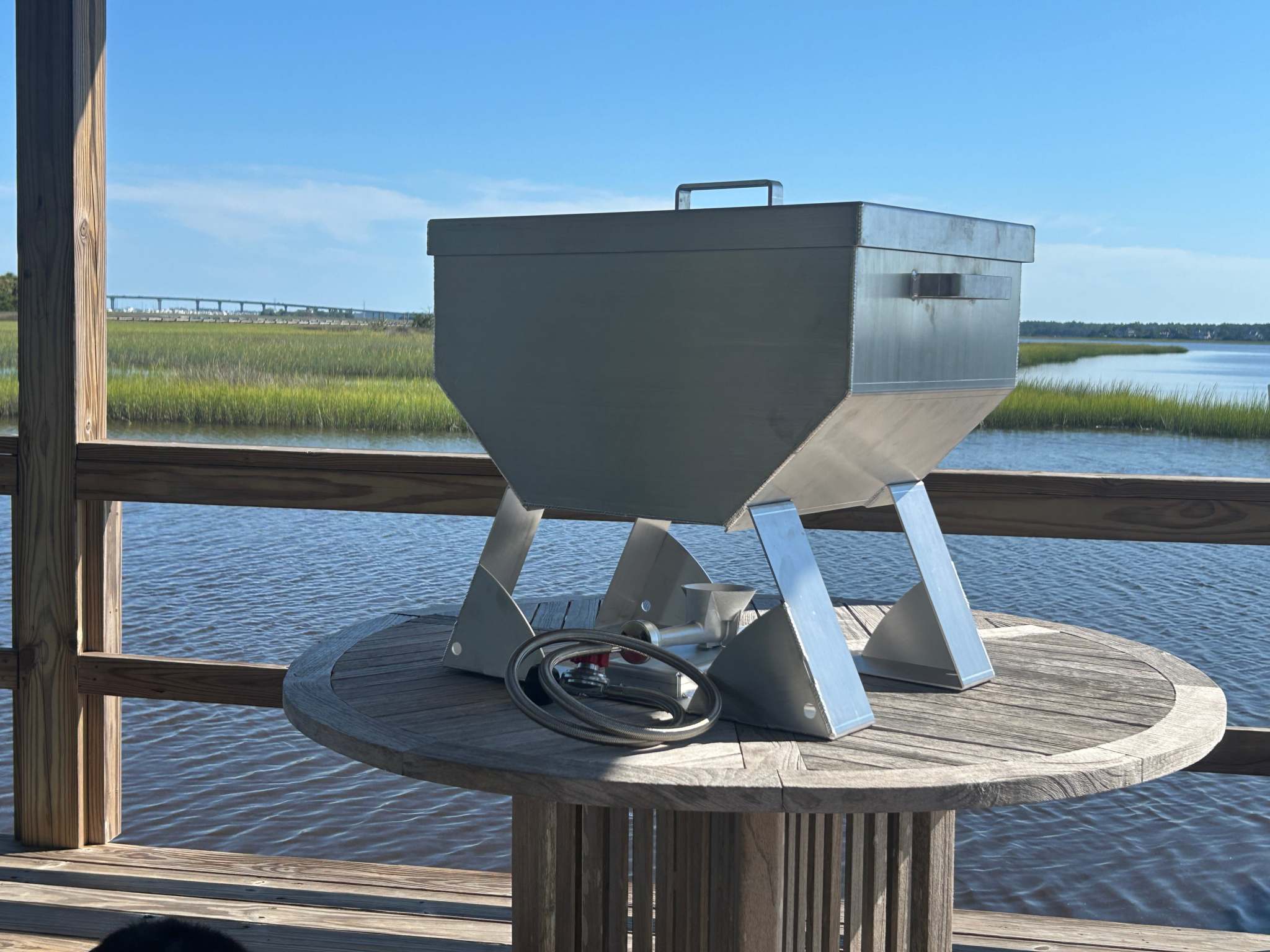 marine grade aluminum oyster steamer cooker designed for outdoor seafood cooking on a wooden table by the water