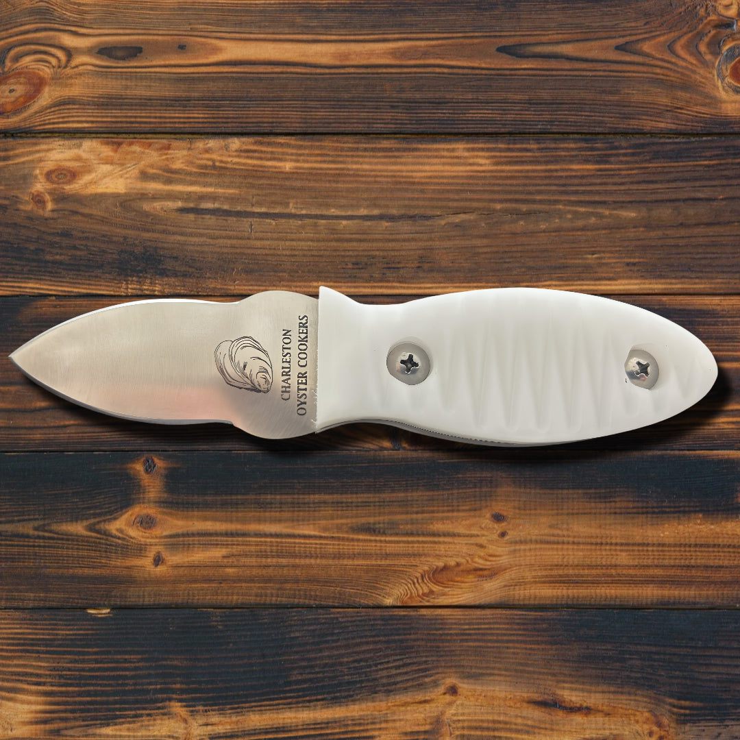 Ultimate Oyster & Shellfish Knife with stainless steel blade and ergonomic white Delrin handle on wooden background